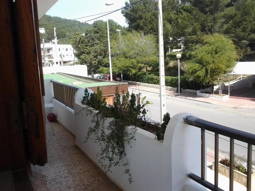 un balcón con una pared blanca con plantas. en Apartment Torres Mari, en Cala Llonga