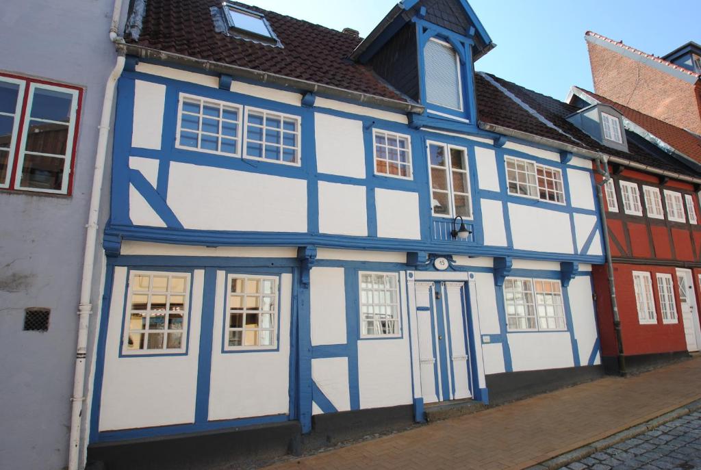 フレンスブルクにあるfewo1846 - Villa Windschief - uriges Fachwerkhaus auf 3 Ebenen mit Garten im Stadtzentrumの通路脇の青白の建物
