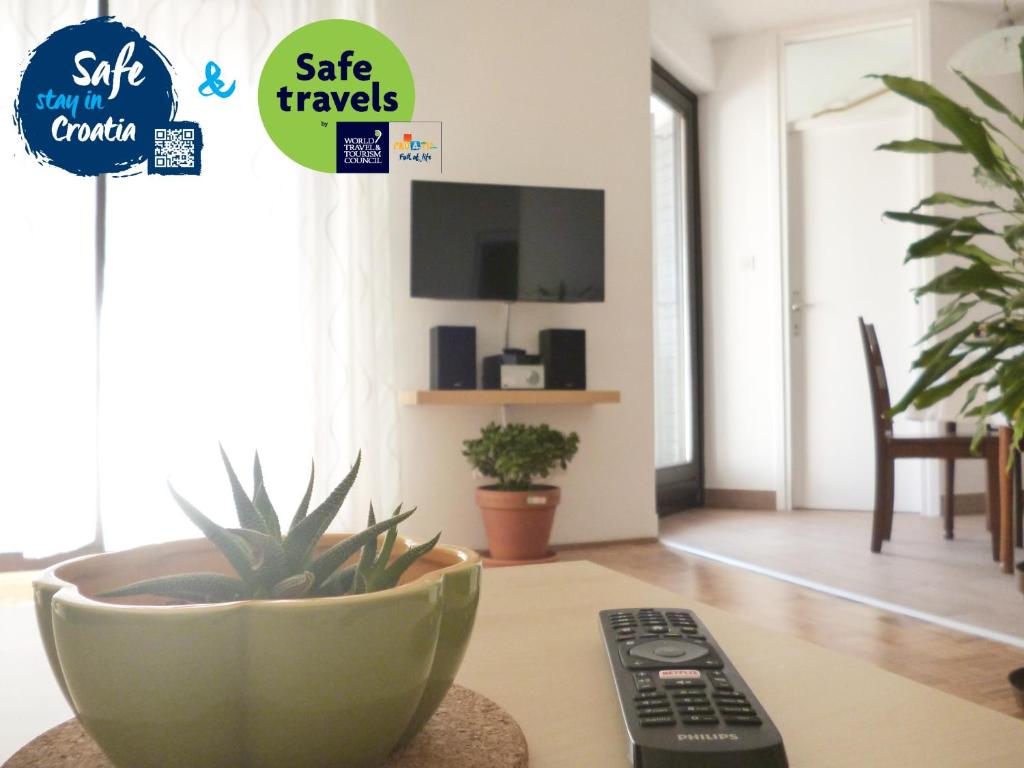 a remote control sitting on a table next to a plant at Apartment Irene in Pula