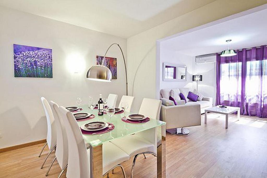 a dining room and living room with a table and chairs at Lavander in Sitges