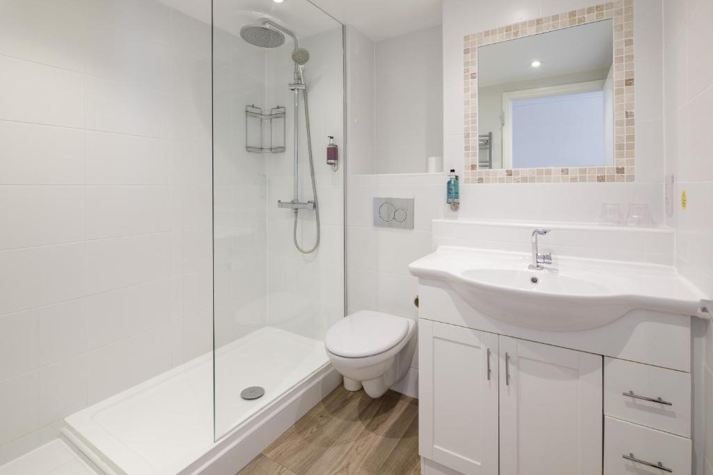 a bathroom with a sink and a toilet and a shower at Ommaroo Hotel in Saint Helier Jersey