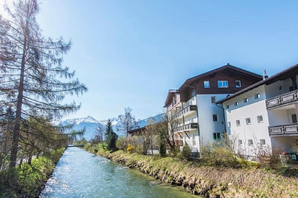 a river next to some buildings and a river at Haus Wallner by AlpenTravel in Bad Hofgastein