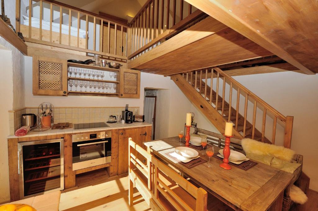 a kitchen with a wooden table and a staircase at Heritage Dürnstein in Dürnstein