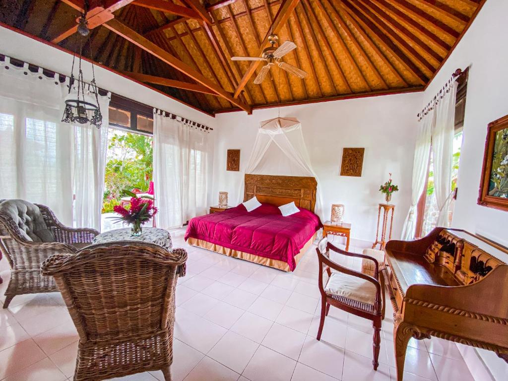a bedroom with a red bed in a room at Cabé Bali in Jasri