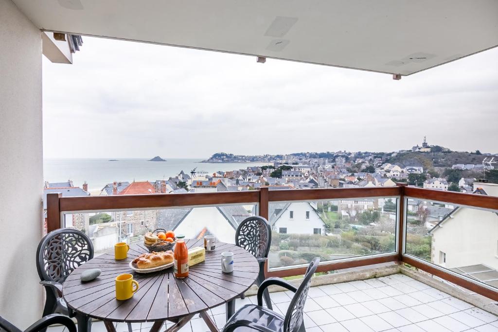 une table et des chaises sur un balcon avec vue dans l'établissement La Lagune - Appartement vue mer Pléneuf-Val-André, à Pléneuf-Val-André