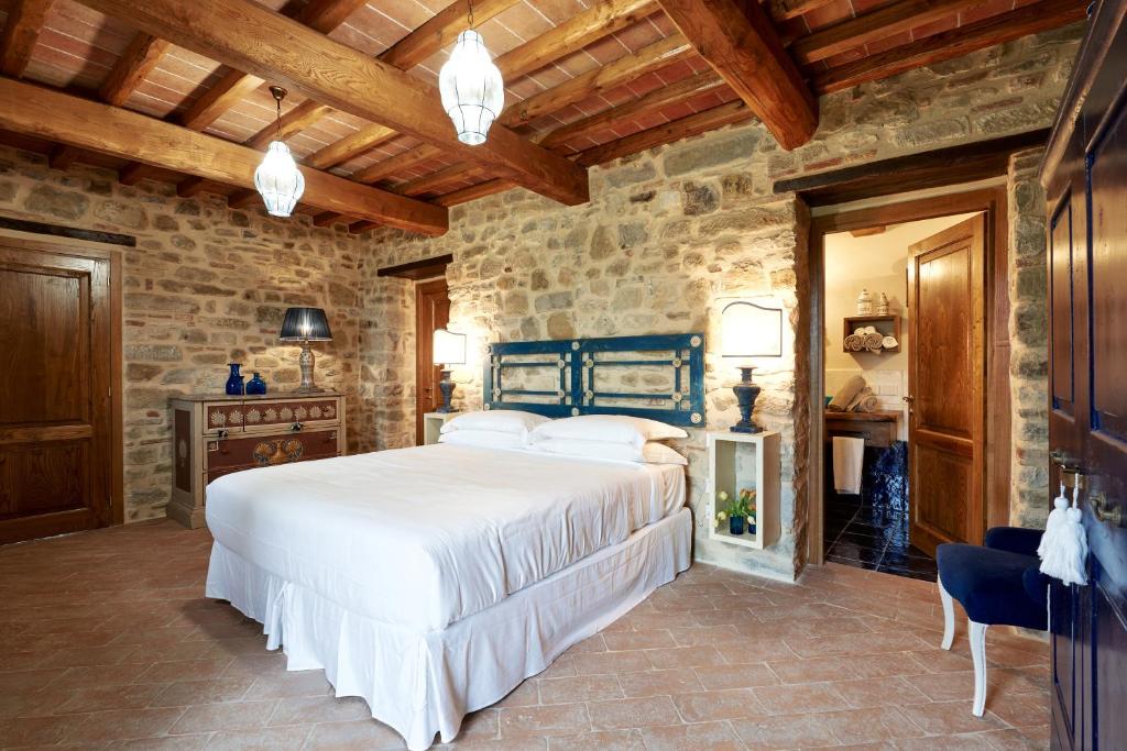 ein Schlafzimmer mit einem Bett und einer Steinmauer in der Unterkunft Podere di Moiata in Campestri