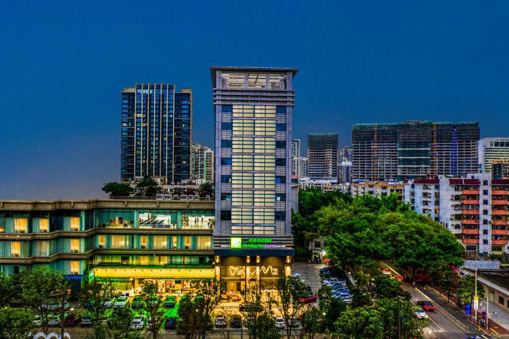 a tall building in a city at night at Holiday Inn Express Shenzhen Nanshan by IHG in Shenzhen