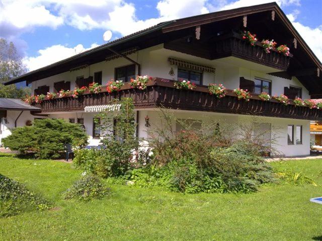 une maison avec un balcon fleuri dans l'établissement Alpenpension Bergidyll, à Schönau am Königssee