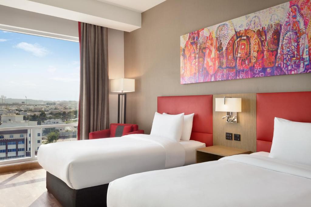 Postel nebo postele na pokoji v ubytování Ramada Encore by Wyndham Muscat Al-Ghubra