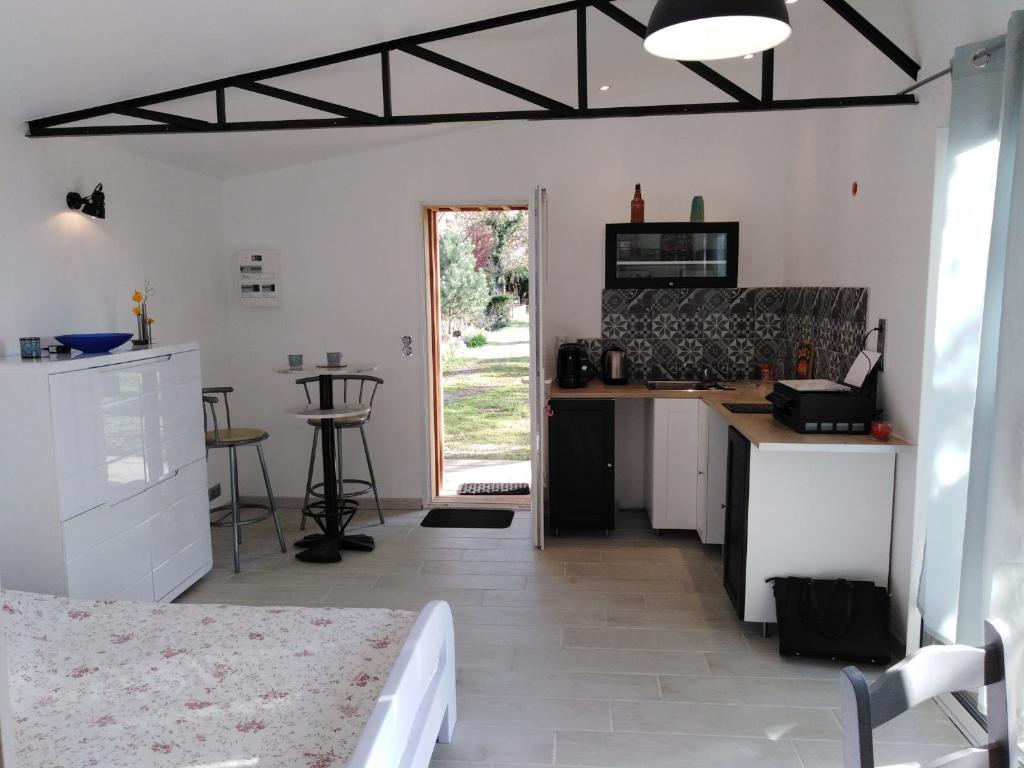 une cuisine avec des armoires blanches et un comptoir dans l'établissement Le chalet du Bord de l'eau, à Sainte-Terre