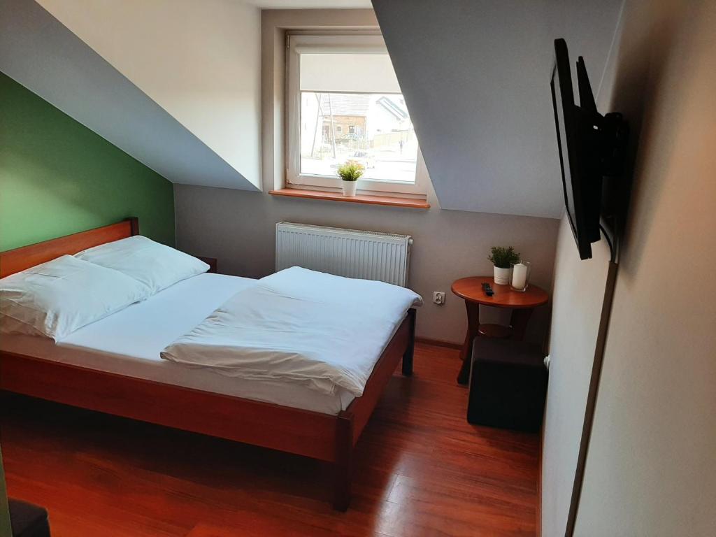 a small bedroom with a bed and a window at Smaczny Zakątek in Ruchocice