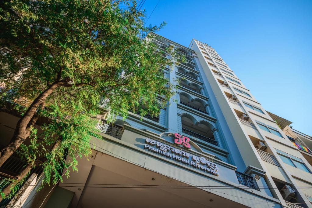 a building with a tree in front of it at Phuminh Hotel Riverside in Phnom Penh