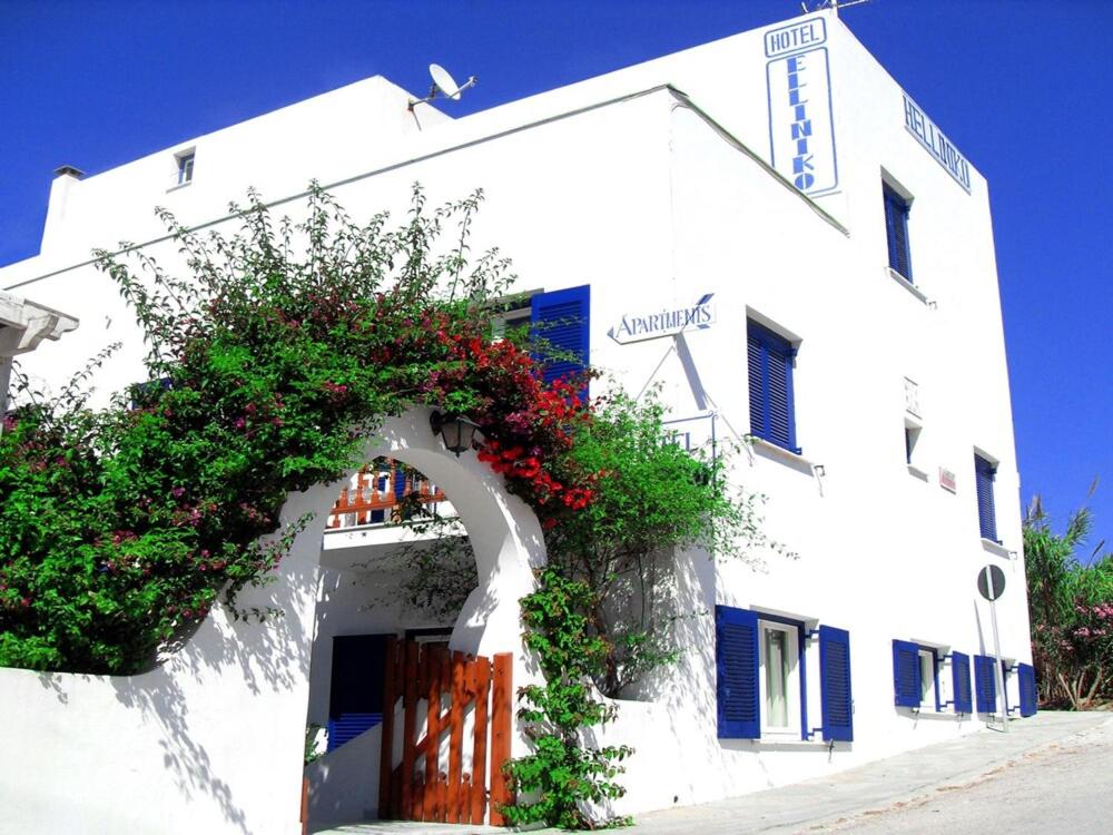 a white building with flowers on the side of it at Helliniko Studios in Parikia