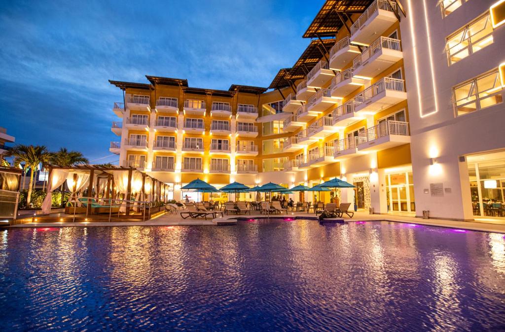 a hotel with a swimming pool at night at Vidam Hotel Aracaju - Transamerica Collection in Aracaju