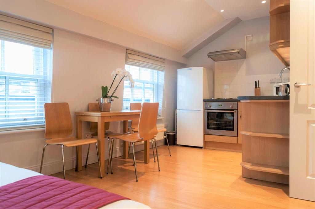 a kitchen and dining room with a table and chairs at 12 London Street Apartments in London