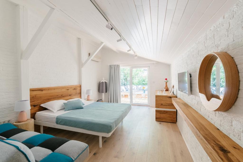 um quarto branco com uma cama e um espelho em Friends Hotel em Lozenets