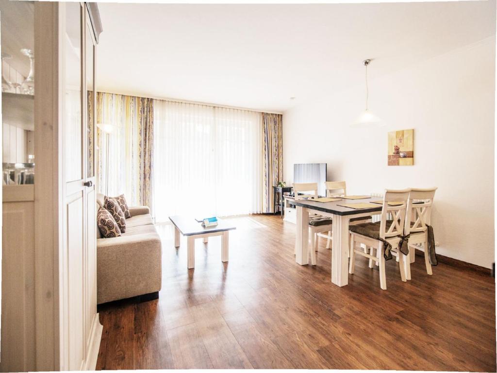 ein Wohnzimmer mit Tisch und Couch in der Unterkunft Dünenpark Binz - Komfortplus Ferienwohnung mit 1 Schlafzimmer und Terrasse im Erdgeschoss 099 in Binz
