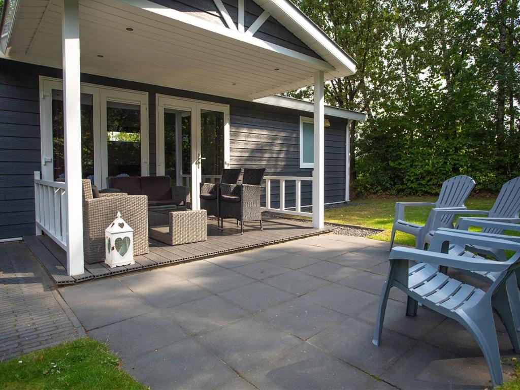 un porche cubierto con sillas y una casa en Modern chalet with covered terrace in nature, en Rhenen