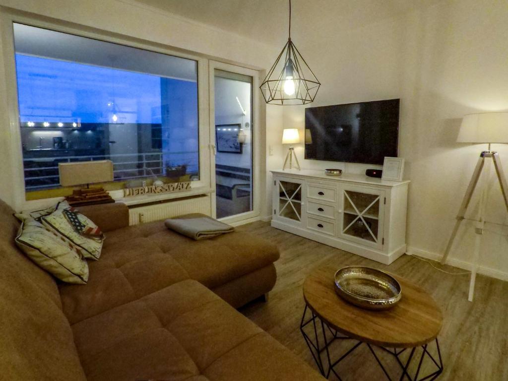 sala de estar con sofá y TV de pantalla plana en Seedeich, en Cuxhaven