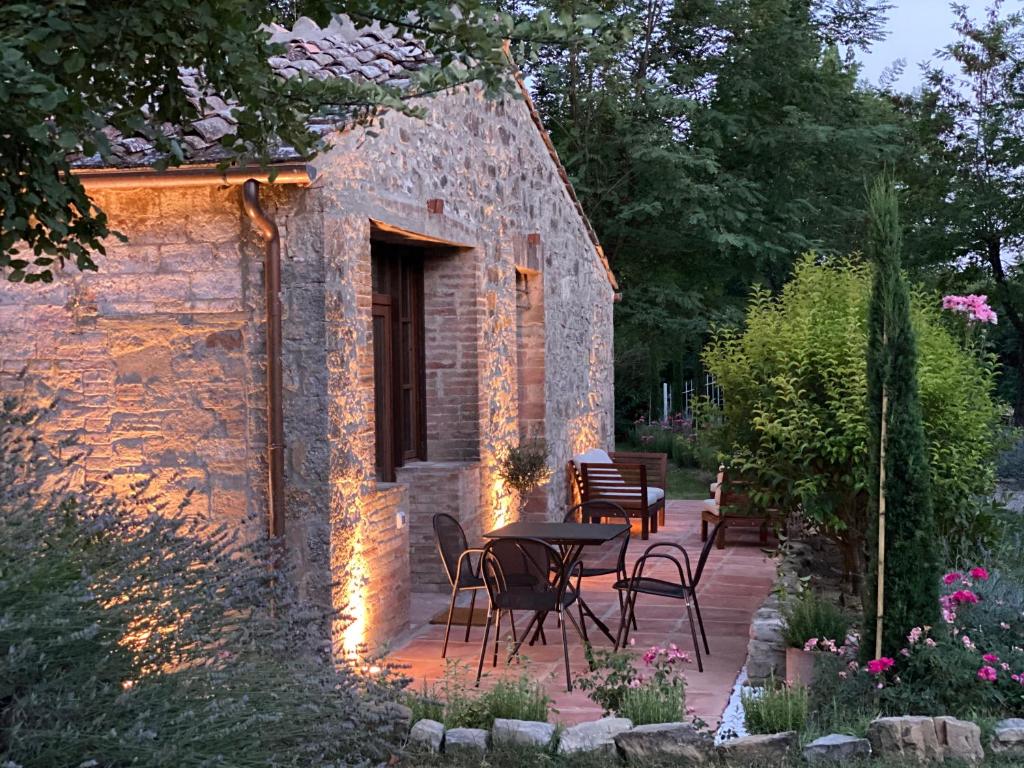 patio ze stołem i krzesłami przed budynkiem w obiekcie Mulino in Chianti w mieście Gaiole in Chianti
