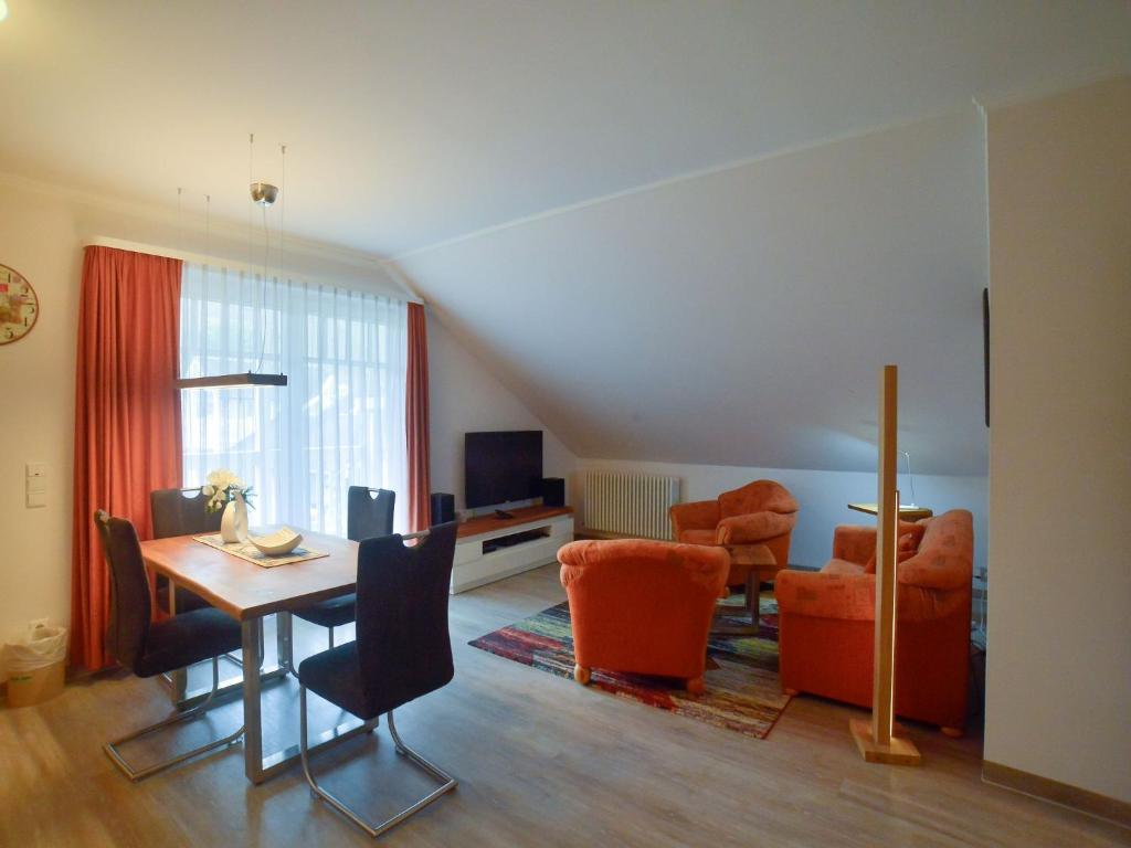 uma sala de estar com uma mesa de jantar e cadeiras em Dünenpark Binz - Komfort Ferienwohnung mit 1 Schlafzimmer und Balkon im Dachgeschoss 147 em Binz