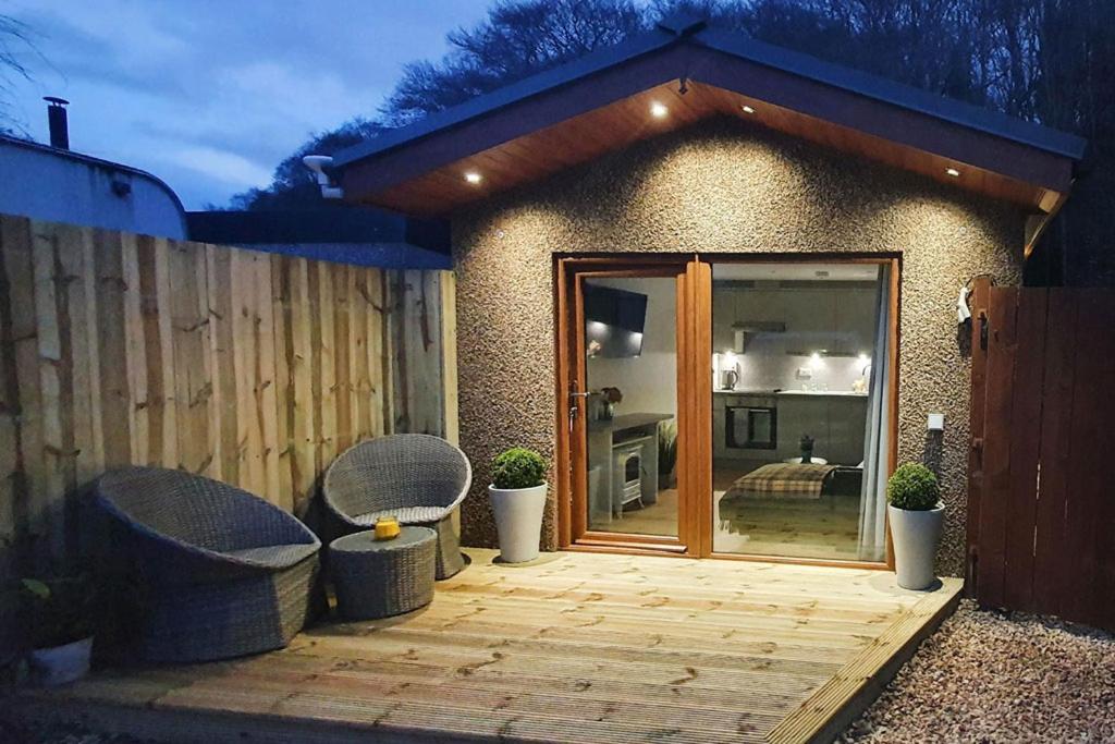 een patio met 2 stoelen en een glazen schuifdeur bij The Nook in Inverness