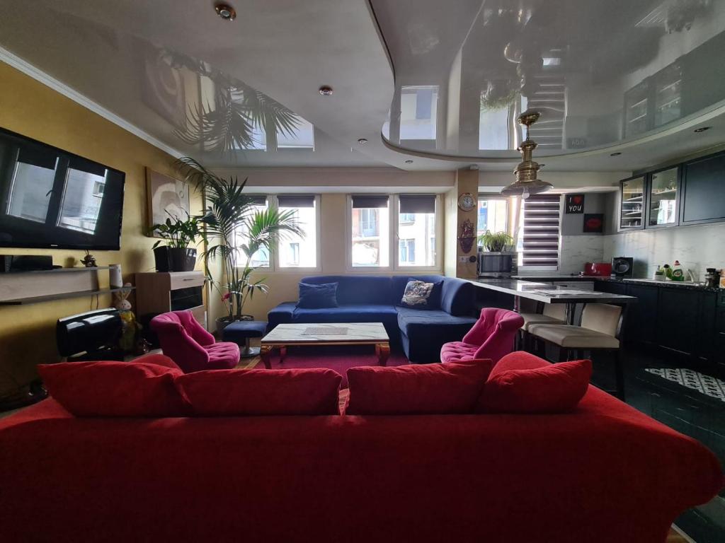 - un salon avec un canapé rouge et une table dans l'établissement Luxueux Appartement, 350m métro Castellane, à Marseille