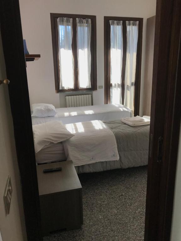 een slaapkamer met 2 bedden en een spiegel bij Camera con bagno Mirjana in Cislago