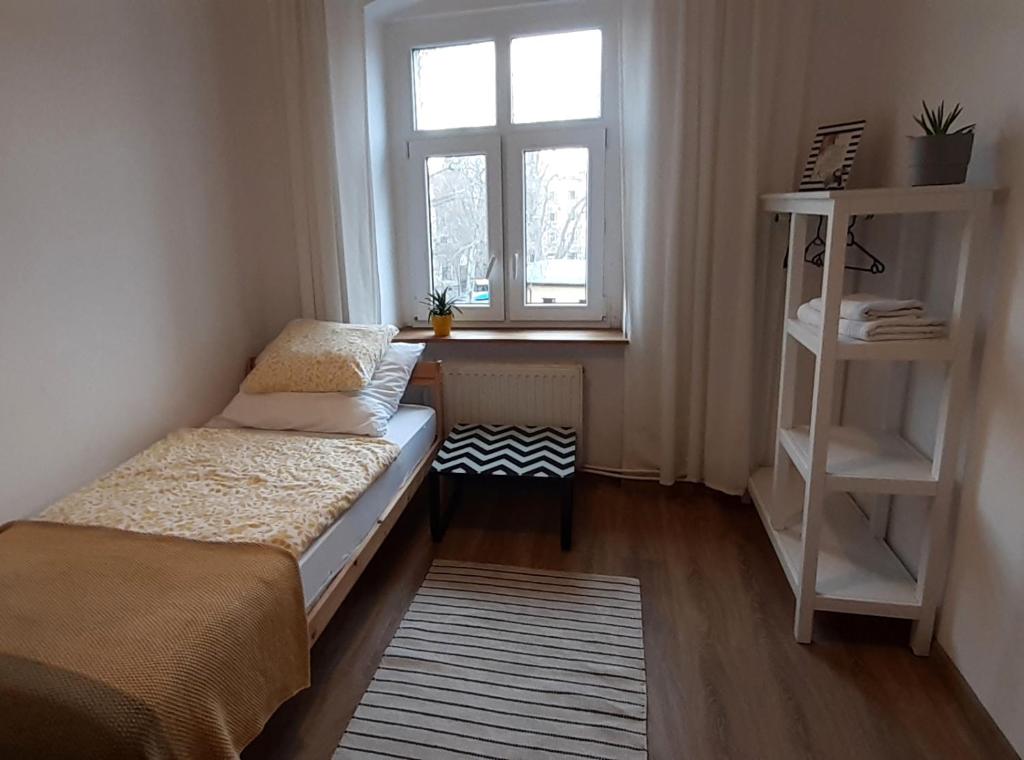 a small room with a bed and a window at Lemuria Hostel Szkolna centrum in Legnica