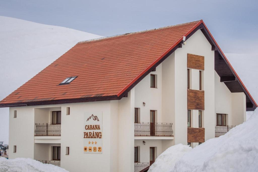 um grande edifício branco com um telhado vermelho em Cabana Parang em Ranca