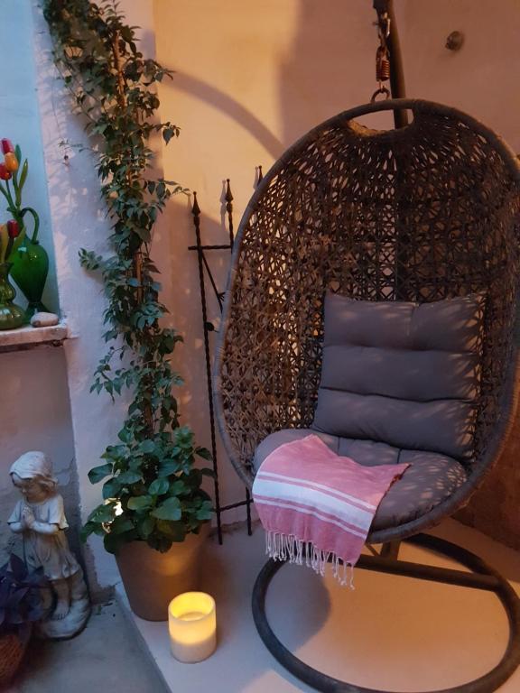 un fauteuil suspendu dans une pièce avec une plante dans l'établissement Bed & Breakfast Bellreguard, à Bellreguart