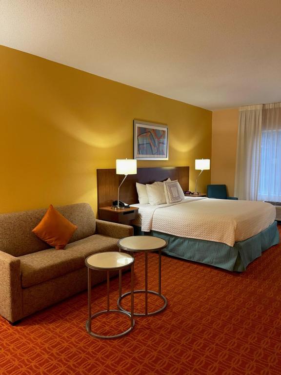 a hotel room with a bed and a couch at Baymont by Wyndham Chambersburg in Chambersburg