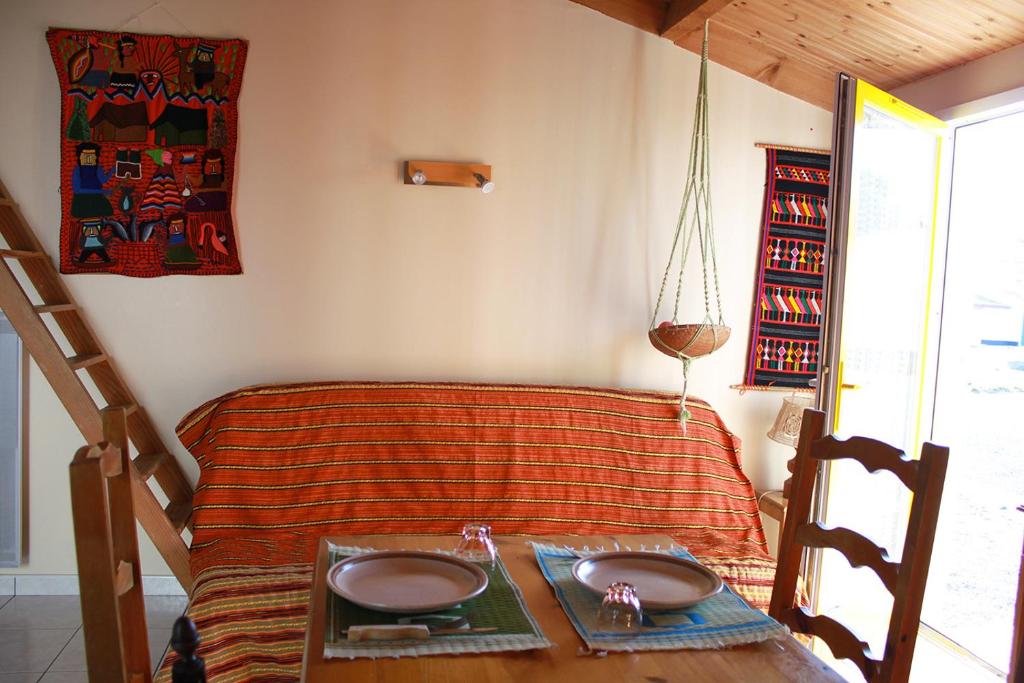 Cette chambre comprend un lit avec une table et un couvre-lit. dans l'établissement Ferme marine pour 4 - Piscine chauffée, à Bretignolles-sur-Mer