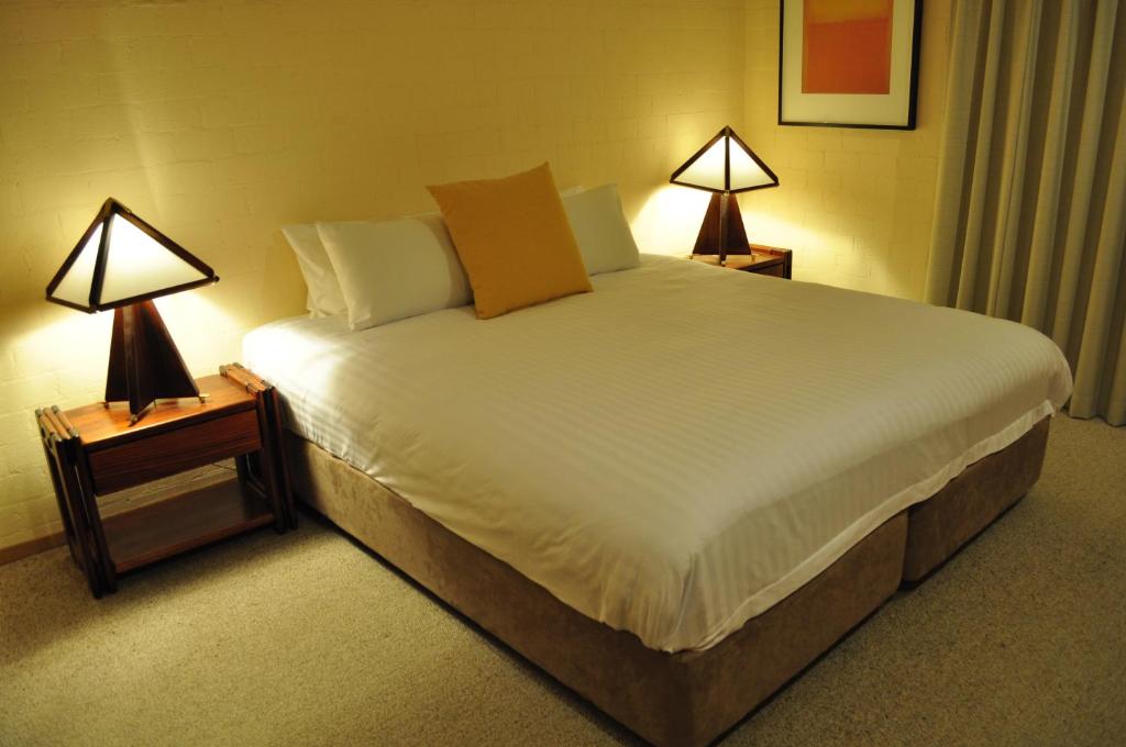 a bedroom with a large bed with two lamps at Salzburg Apartments in Perisher Valley