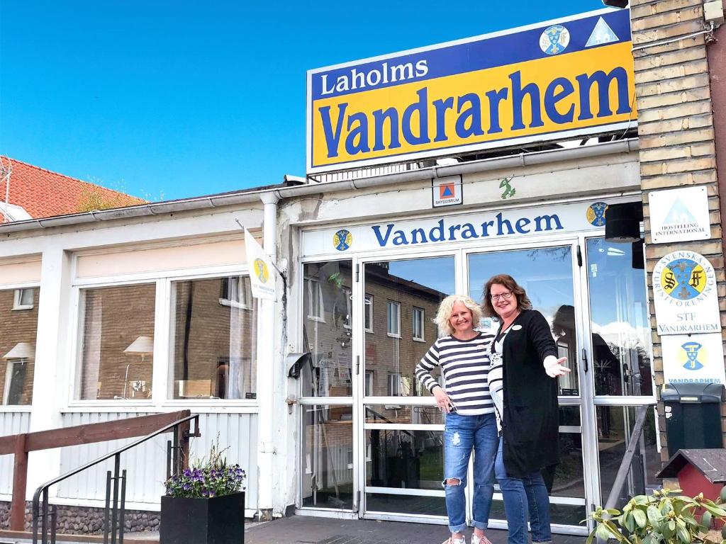 Duas mulheres estão em frente a uma loja. em Laholms Vandrarhem em Laholm