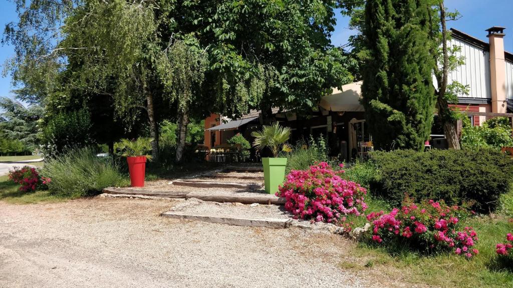 洛斯彼特勒特杜拉茲的住宿－Camping Au Tour de l'Aveyron，一座花园,在房子前方种有粉红色的花朵