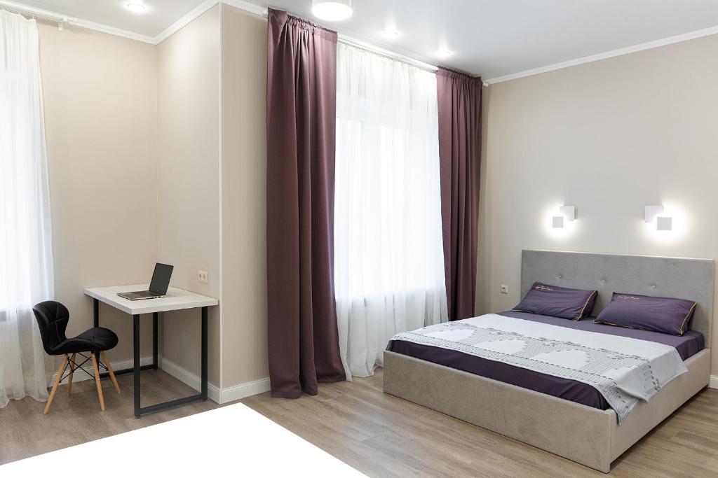 una camera con letto e scrivania con computer portatile di Apartment Comfort plus IQ a Gatchina