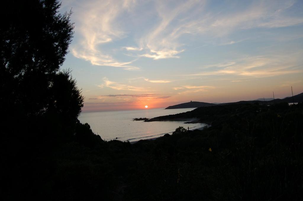 um pôr do sol sobre um corpo de água com o pôr do sol em Villa Rosetta em Chia