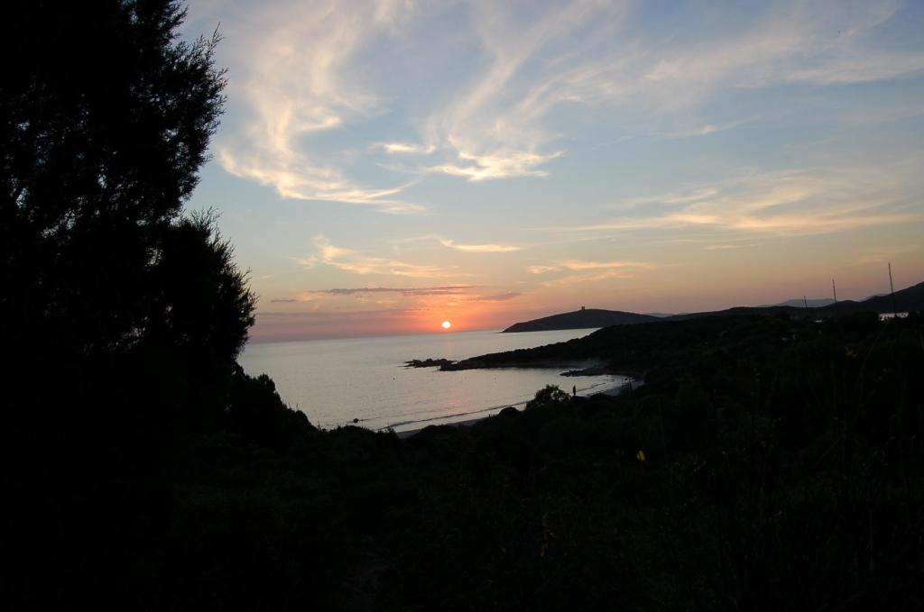 a sunset over a body of water with the sun setting at Villa Rosetta in Chia