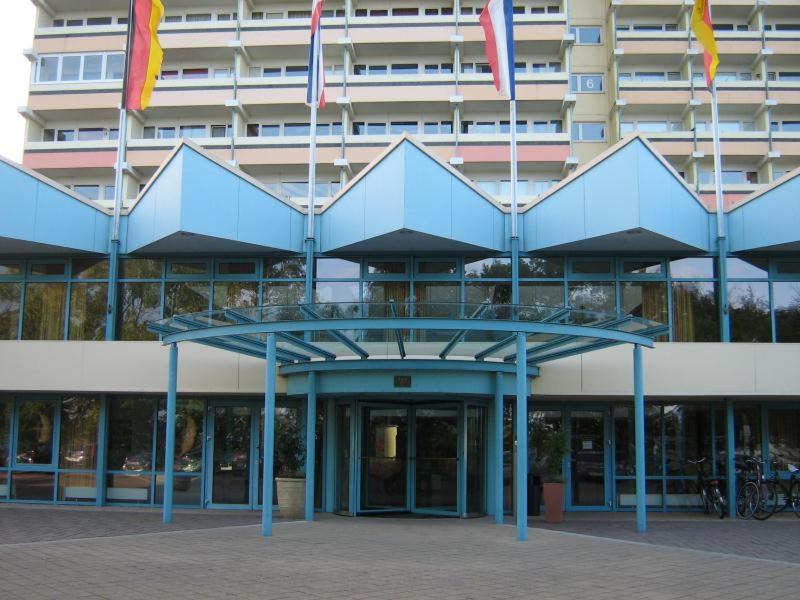 un bâtiment bleu avec drapeaux devant lui dans l'établissement Ferienappartement K315 für 2-4 Personen in Strandnähe, à Schönberg in Holstein