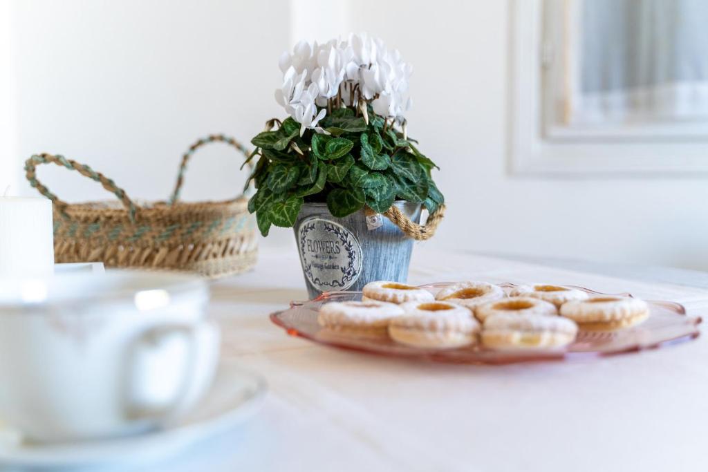 uma mesa com um prato de donuts e um vaso com uma planta em Casa Silvia em Marina di Campo