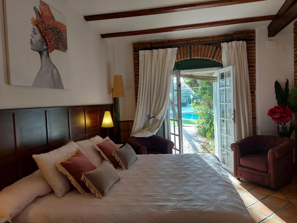 sypialnia z łóżkiem i drzwiami prowadzącymi na patio w obiekcie Hotel Don Gonzalo w mieście Montilla