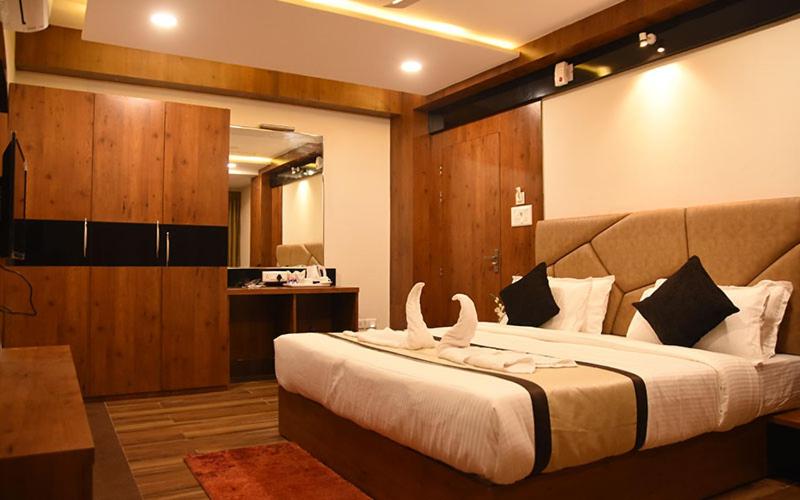 ein Schlafzimmer mit einem großen Bett mit weißen Handtüchern darauf in der Unterkunft Hotel Royal City in Shiliguri