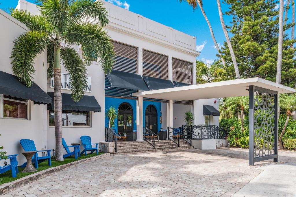 a white house with blue chairs and palm trees at The Landon Bay Harbor-Miami Beach in Miami Beach
