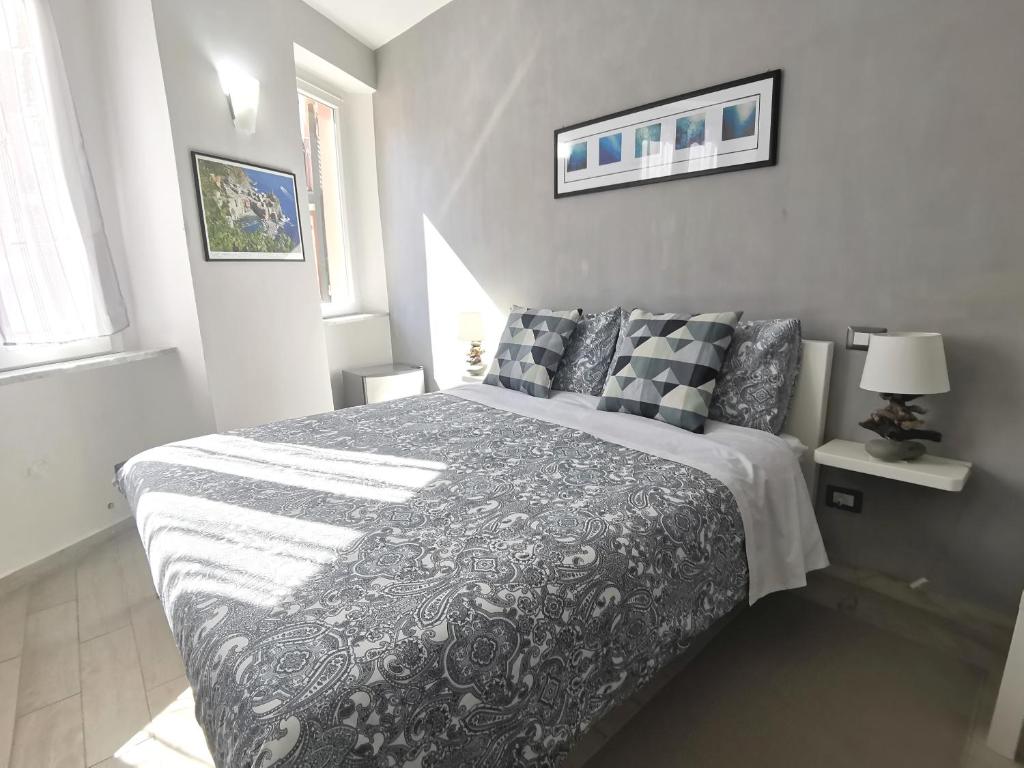 a bedroom with a black and white bed with pillows at SeaBreeze Vernazza in Vernazza
