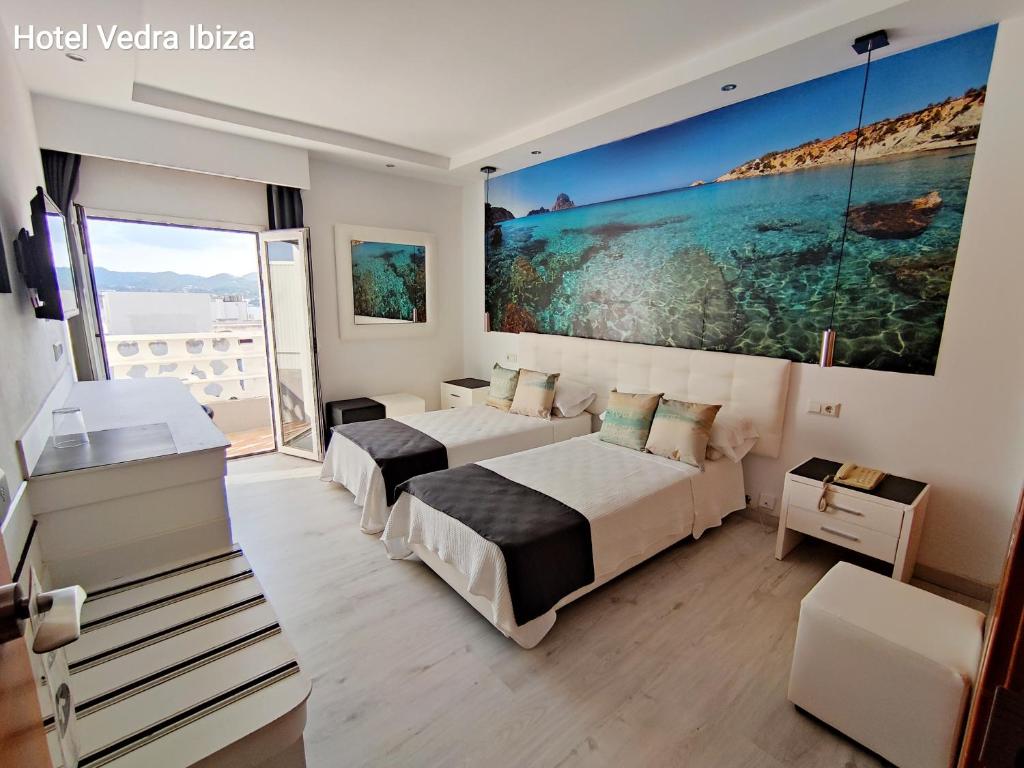 ein Hotelzimmer mit 2 Betten und einem großen Wandgemälde in der Unterkunft Hotel Vedra in Sant Antoni de Portmany