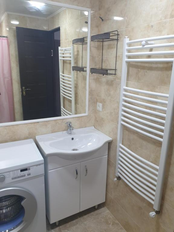 a bathroom with a sink and a toilet and a mirror at Apartament in chirie Moldova or.Soroca in Soroca
