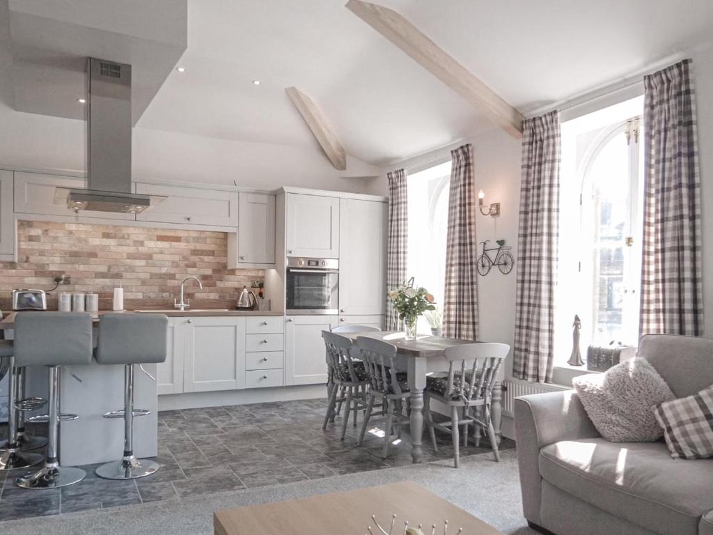 una cucina e un soggiorno con tavolo e sedie di Crescent View a Buxton