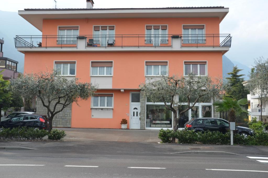 加爾達湖濱的住宿－Casa Family Riva del Garda，一座橙色的建筑,前面有汽车停放