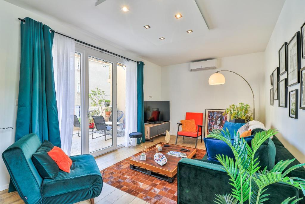 een woonkamer met twee blauwe stoelen en een tafel bij Canopée - Toulon Mourillon - 800m des plages et place de parking privé in Toulon